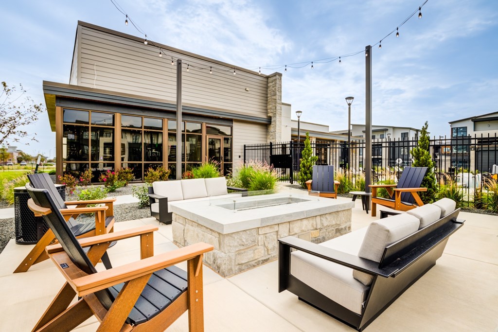 A patio with a hot tub and chairs.