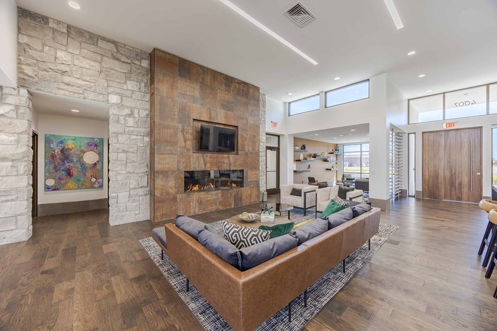 A modern living room with a stone fireplace and a large sectional sofa.