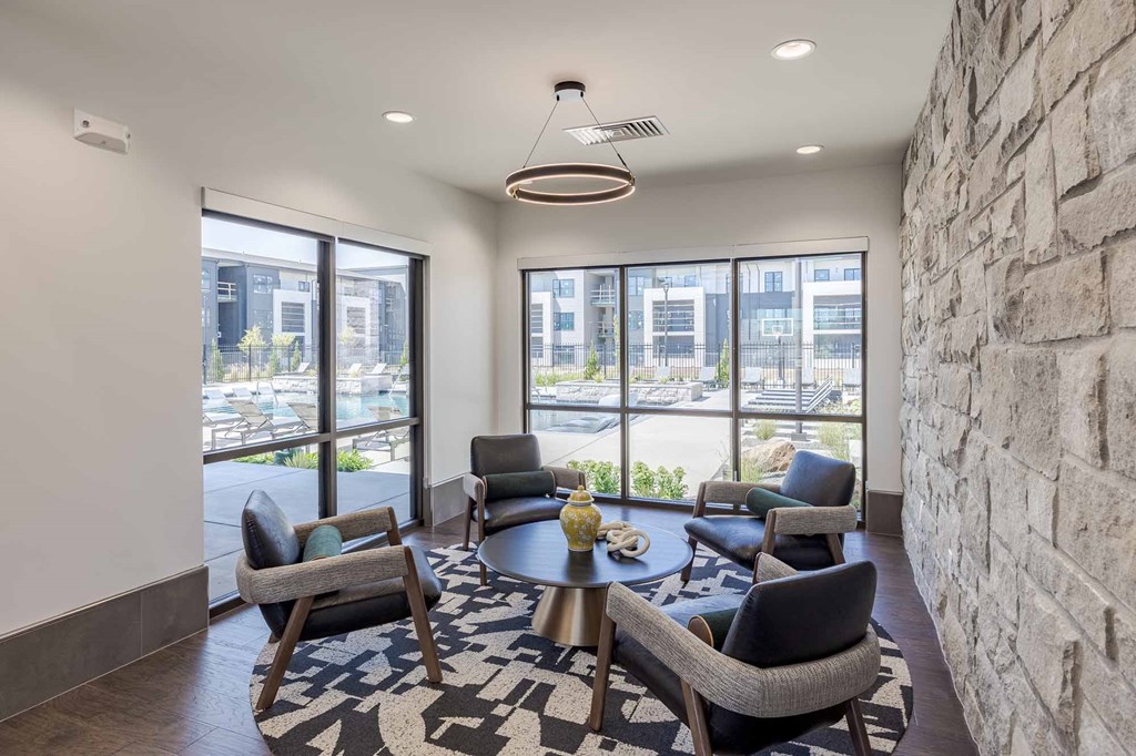 A room with a stone wall and a table with chairs.