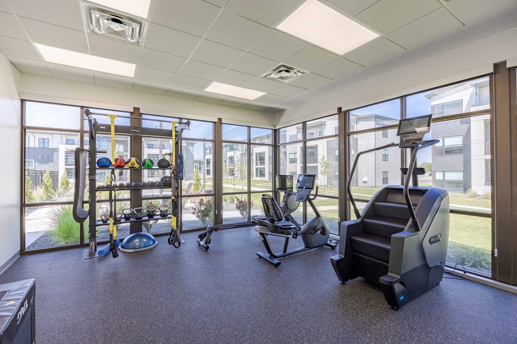 A gym with a treadmill, elliptical trainer, and other exercise equipment.