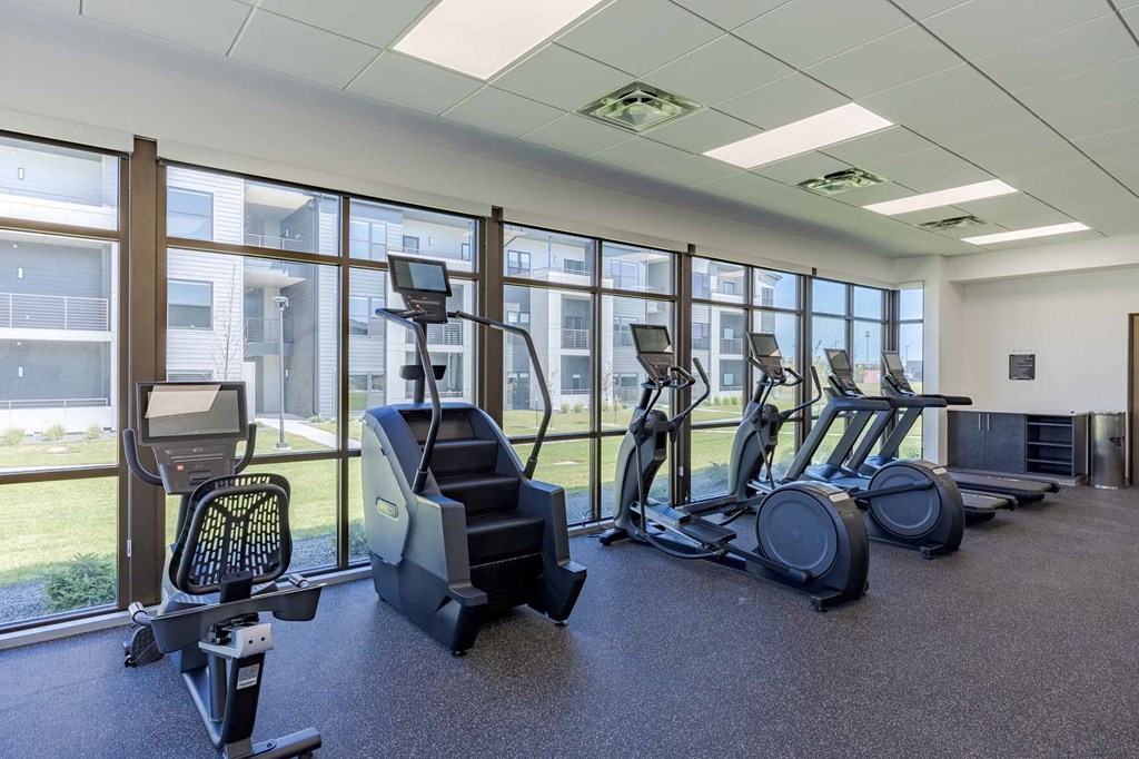 A gym with treadmills, elliptical machines, and other exercise equipment.
