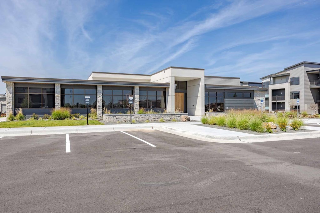 A modern building with a parking lot in front.