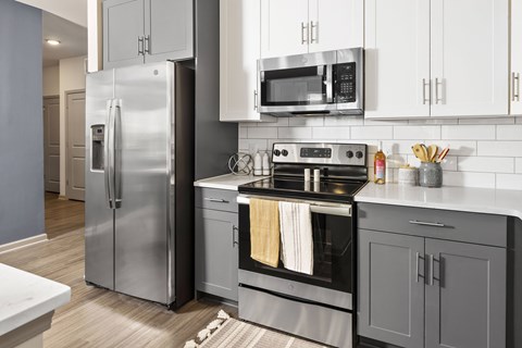 A modern kitchen with a stainless steel refrigerator and oven.