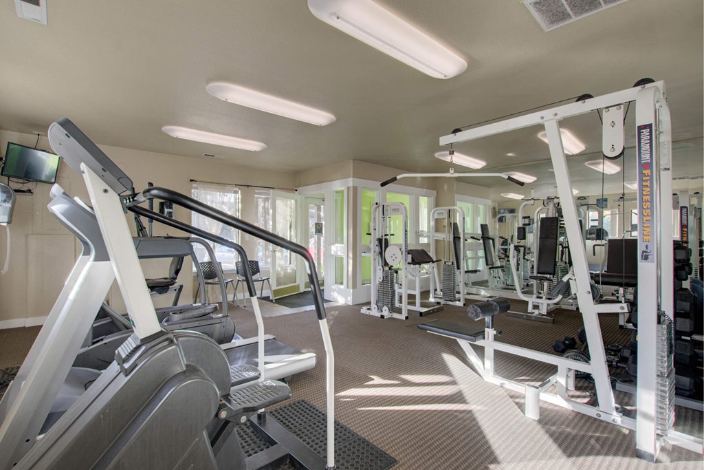 A gym with treadmills, weights, and exercise machines at Aspenridge Apartments, Washington