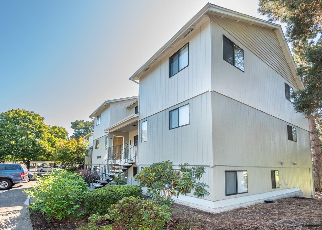 A modern two-story building with a white exterior and a balcony on the second floor at Aspenridge Apartments, Vancouver, WA