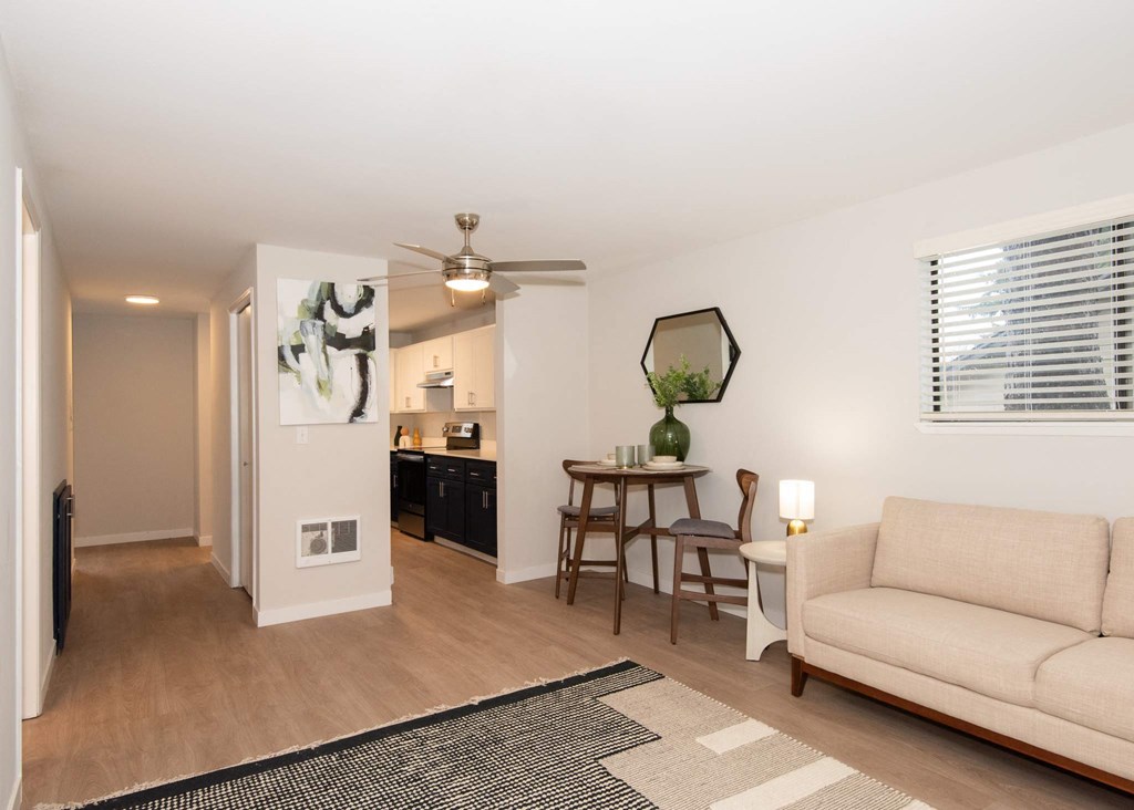 A living room with a couch, a table, and a ceiling fan at Aspenridge Apartments,Vancouver, WA