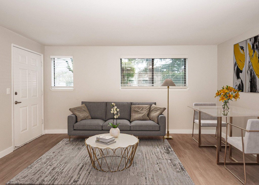 A living room with a grey couch, a white coffee table, and a grey rug at Aspenridge Apartments, Vancouver