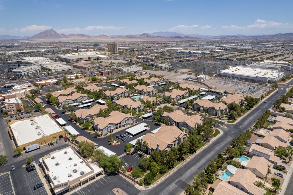A large aerial view of a residential area with houses, roads, and a parking lot.