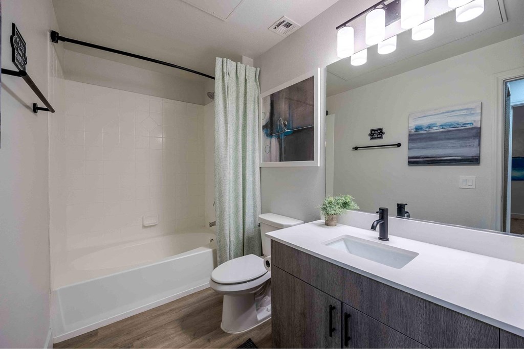 A bathroom with a white sink and a white toilet.