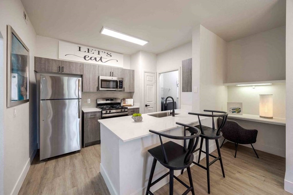 A kitchen with a white island and a refrigerator.