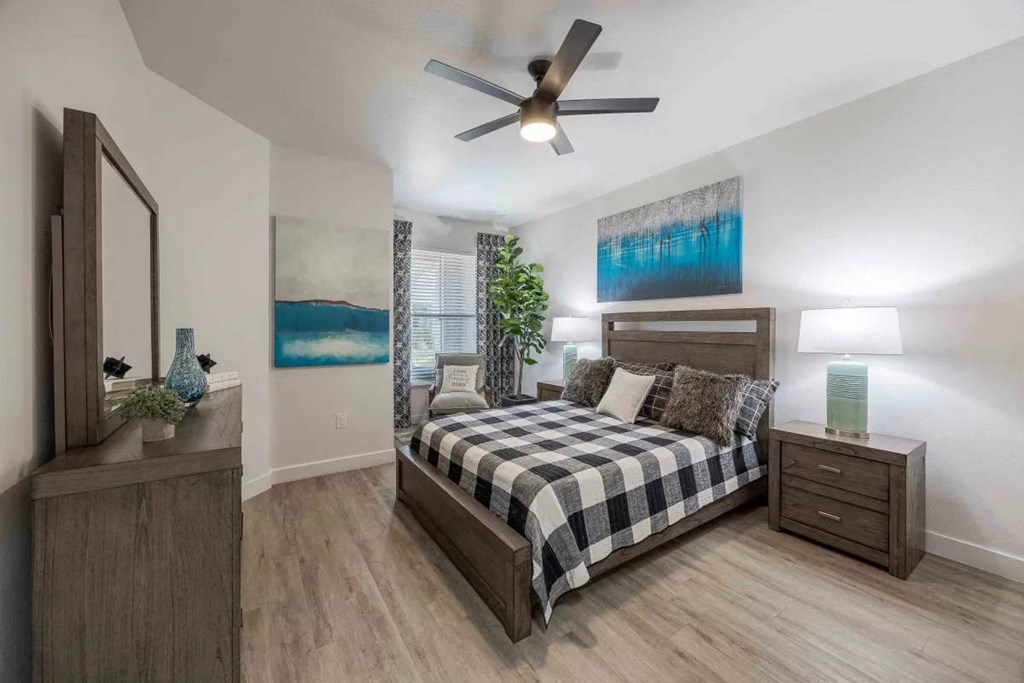 A bedroom with a bed, nightstand, and a mirror.