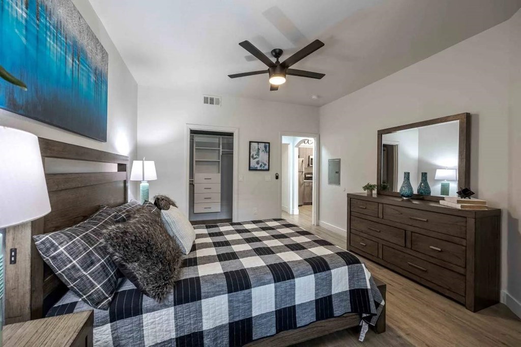 A bedroom with a bed, dresser, and mirror.