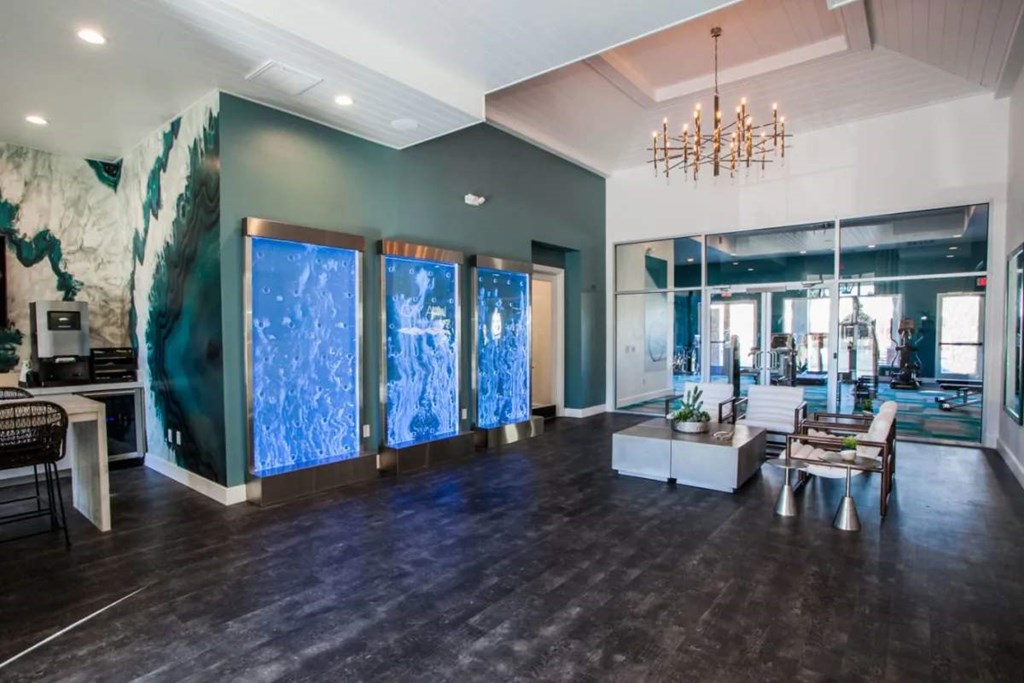 A room with a large painting on the wall and a chandelier hanging from the ceiling.