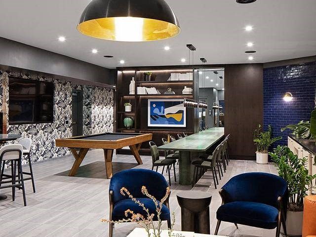 A modern dining room with a pool table and comfortable seating.