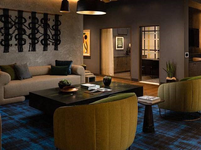 A living room with a couch, a coffee table, and a yellow chair.