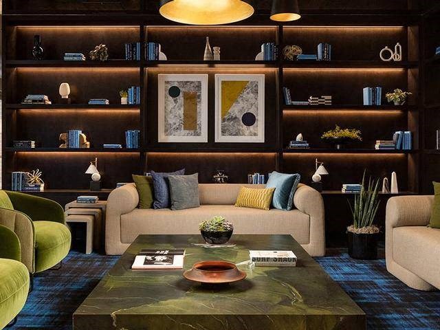 A living room with a green sofa and a coffee table with a bowl on it.