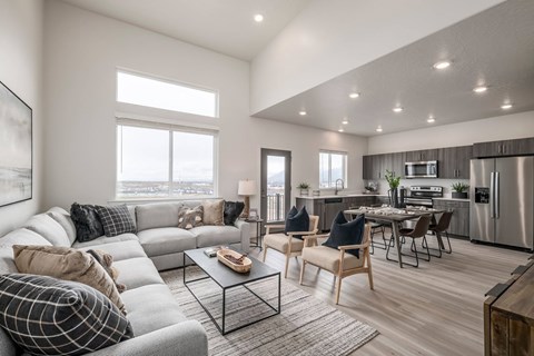 A modern living room with a grey sofa and a glass coffee table.
