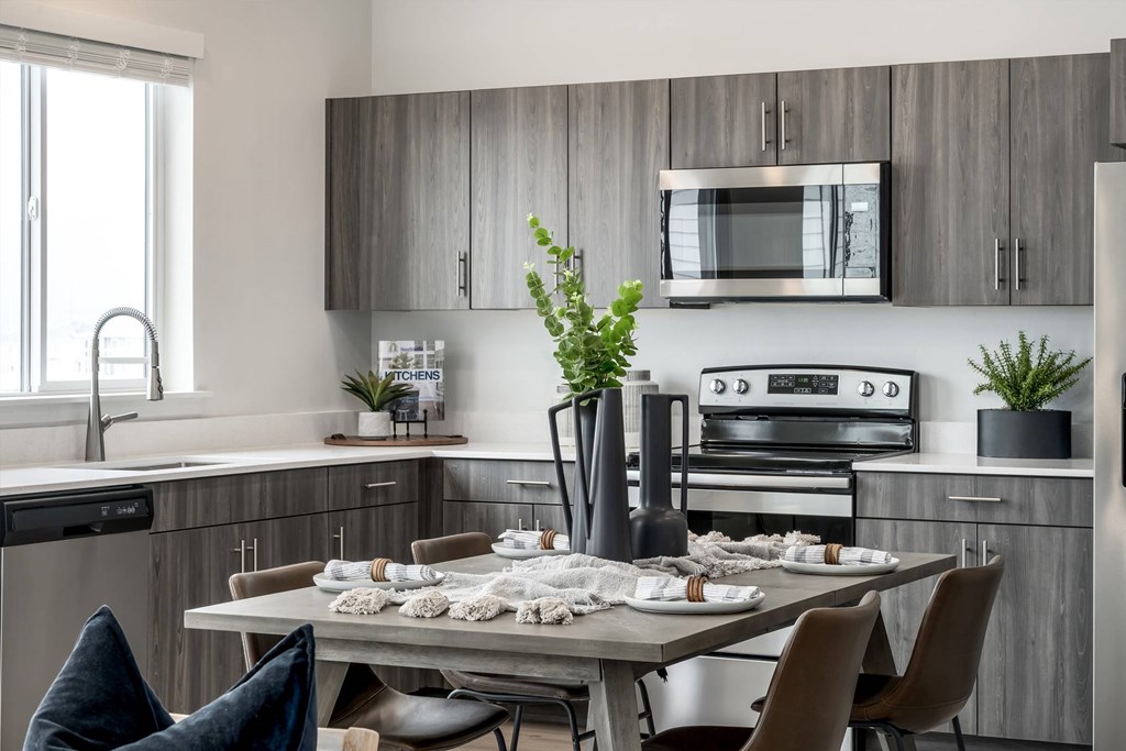 A modern kitchen with a dining table set for two.