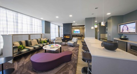 A modern living room with a purple couch and a television.