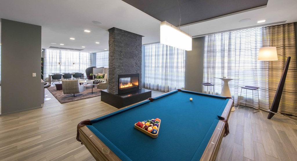 A pool table with a green cloth and a set of pool balls in the middle.