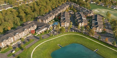 A large building complex with a pond in front.