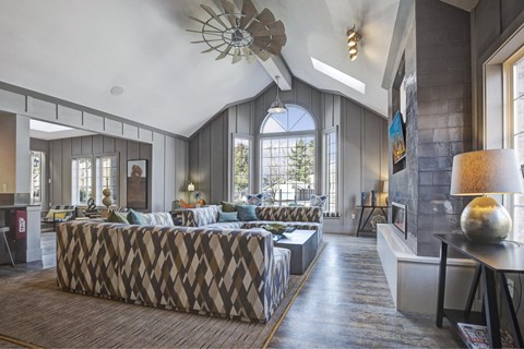A living room with a patterned sofa and a wooden floor.