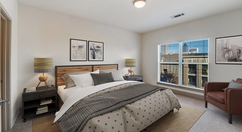 A bedroom with a large bed and a view of the city.
