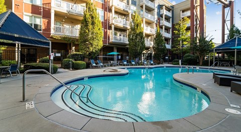 A swimming pool in a courtyard surrounded by buildings.