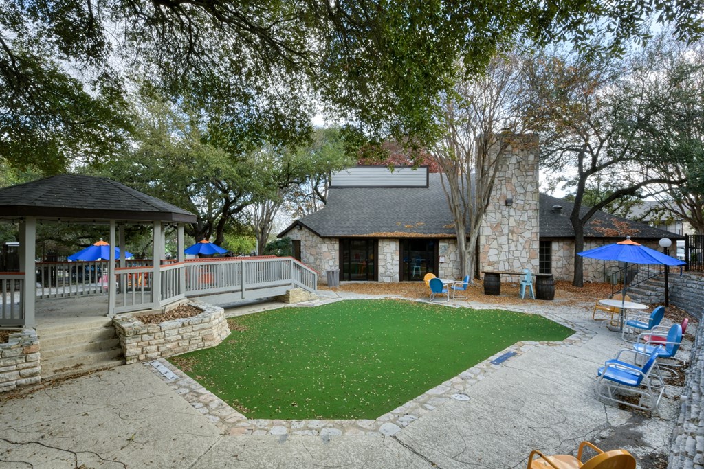 A backyard with a green lawn and a gazebo.