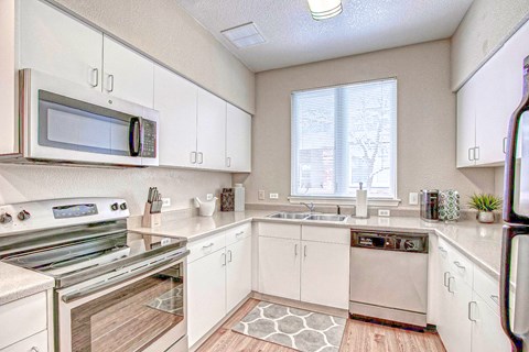 A kitchen with white cabinets and appliances.