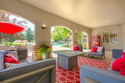 A living room with a grey couch and a red umbrella.
