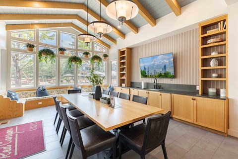 A dining room with a long table and chairs.