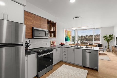 A modern kitchen with a stainless steel refrigerator and a microwave above the stove.