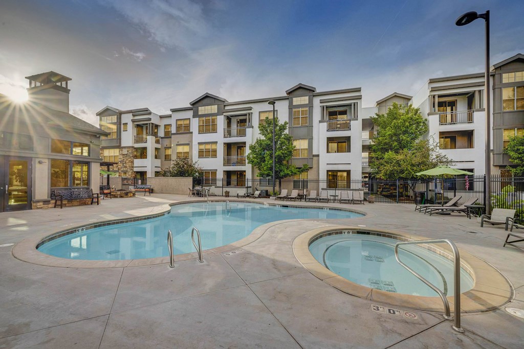 A large swimming pool in front of apartment buildings.