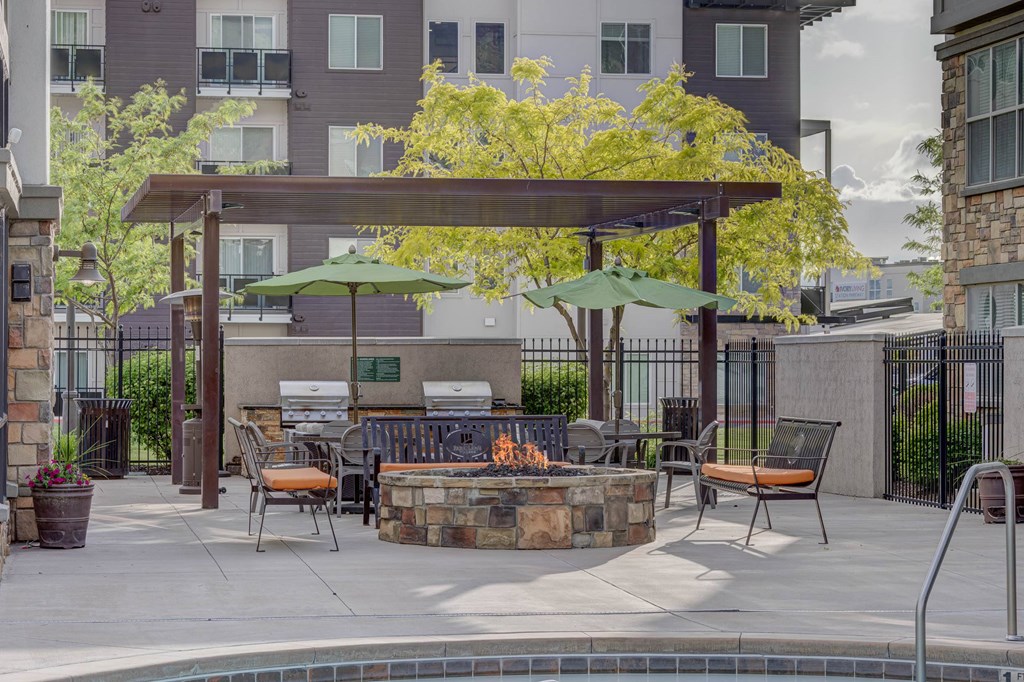 A patio with a fire pit and seating area.