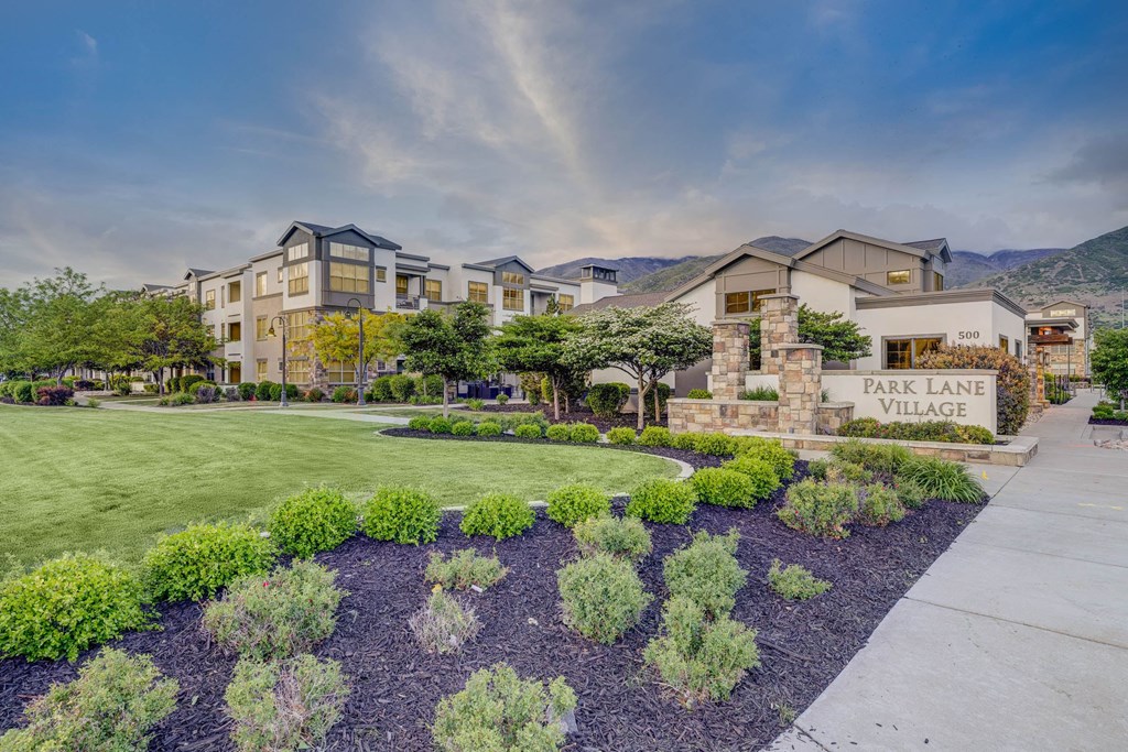 A large building with a sign that says "Park Lane Village" in front of it.