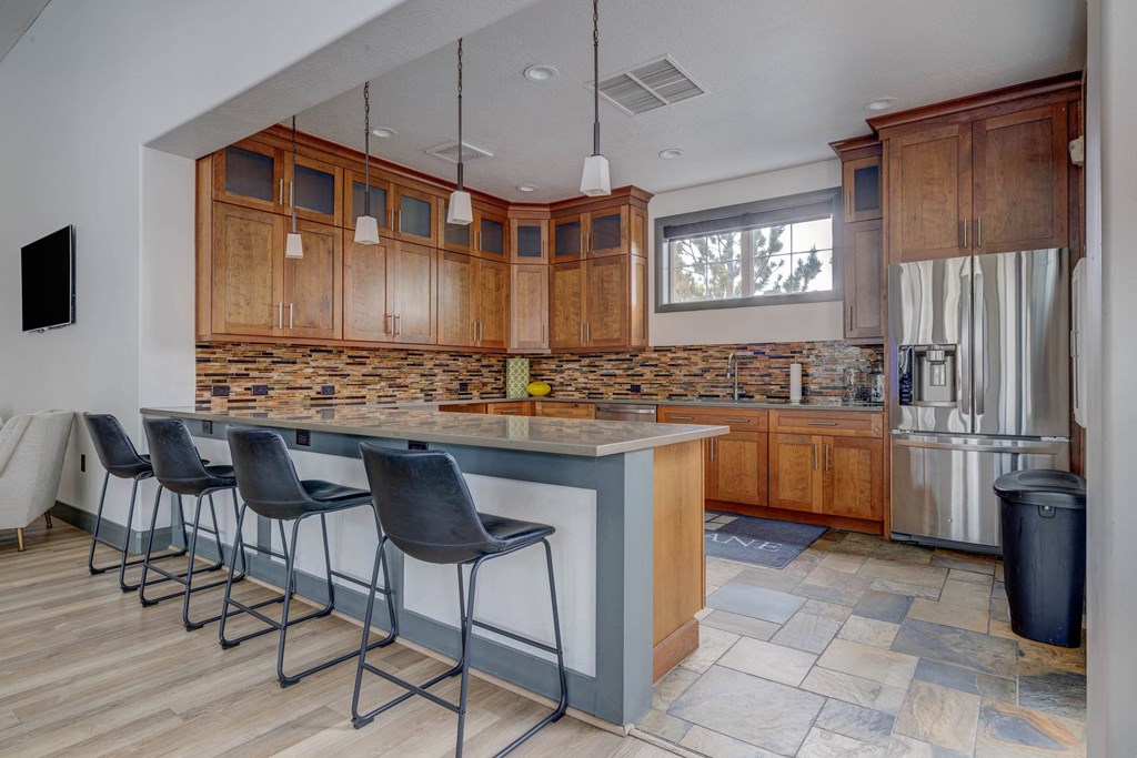 A kitchen with a bar area and chairs.