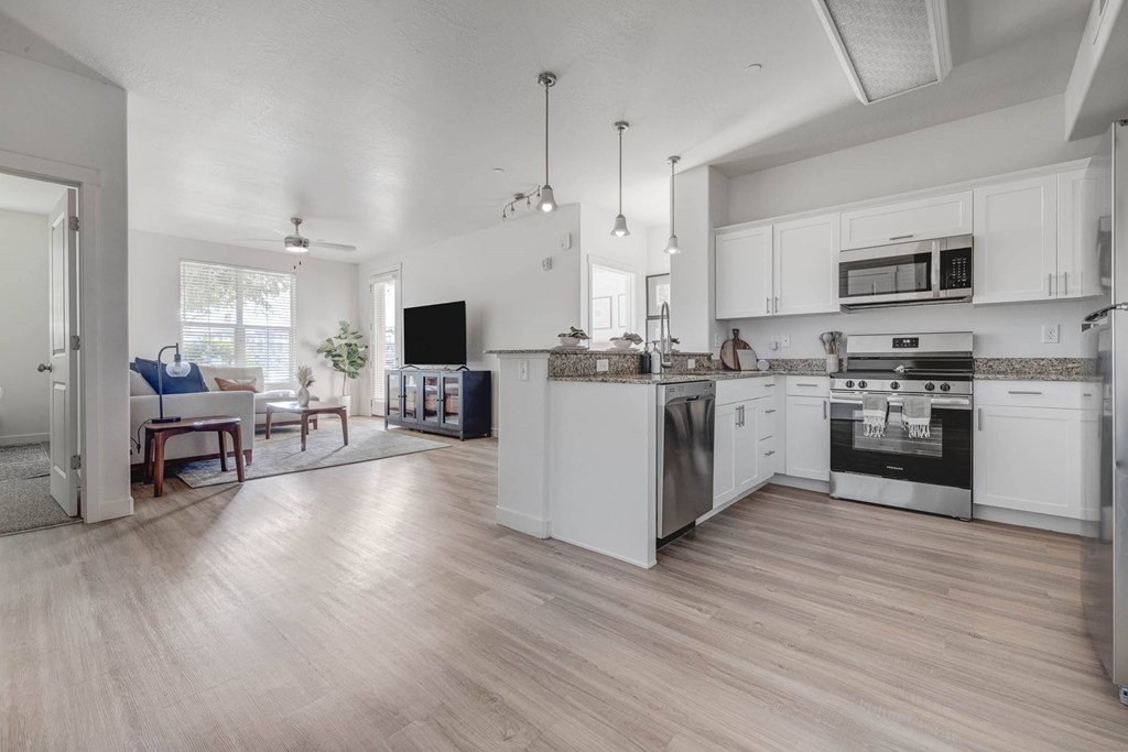 A modern kitchen with white cabinets and stainless steel appliances.