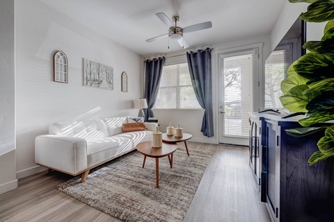 A living room with a white couch and a ceiling fan.