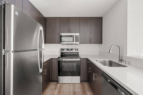 A modern kitchen with a stainless steel refrigerator and a stove top oven.