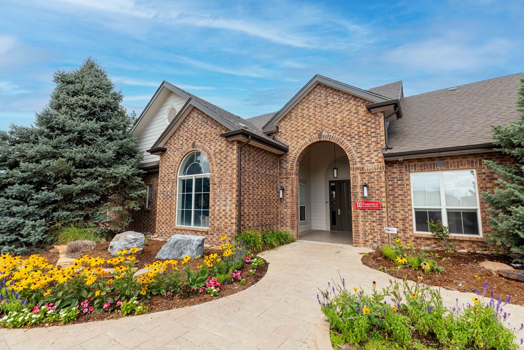 the front of a brick house with a courtyard and flowers