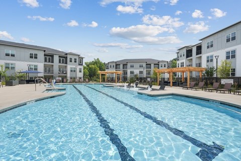 A large swimming pool in front of apartment buildings.