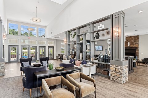 A modern living room with a stone fireplace and a dining table with chairs.