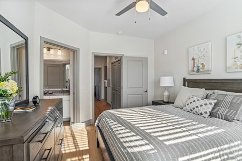 A bedroom with a large bed and a ceiling fan.