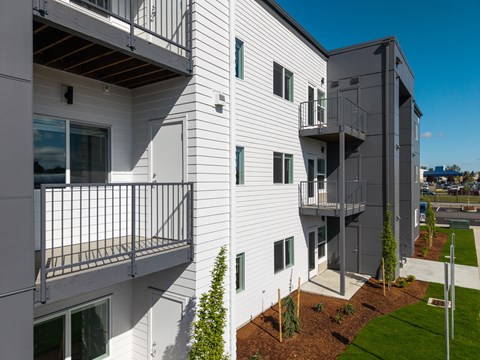 Modern apartment building with white siding and balconies at The Arvon, WA 98662