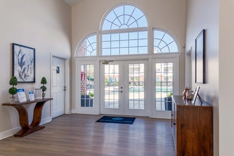 the inside of the clubhouse with large arched window and a wooden table.