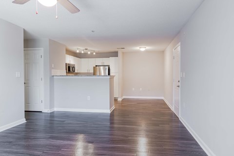 A spacious room with a kitchen area in the background.