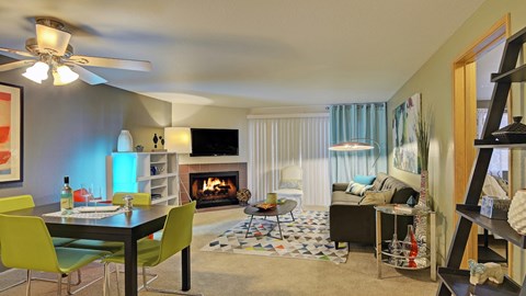 A living room with a fireplace, a dining table and chairs, and a television.