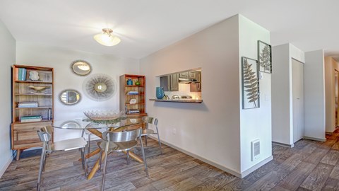 A dining room with a wooden table and chairs.