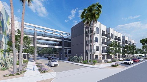 A street view of a modern building with a white car driving on the road.
